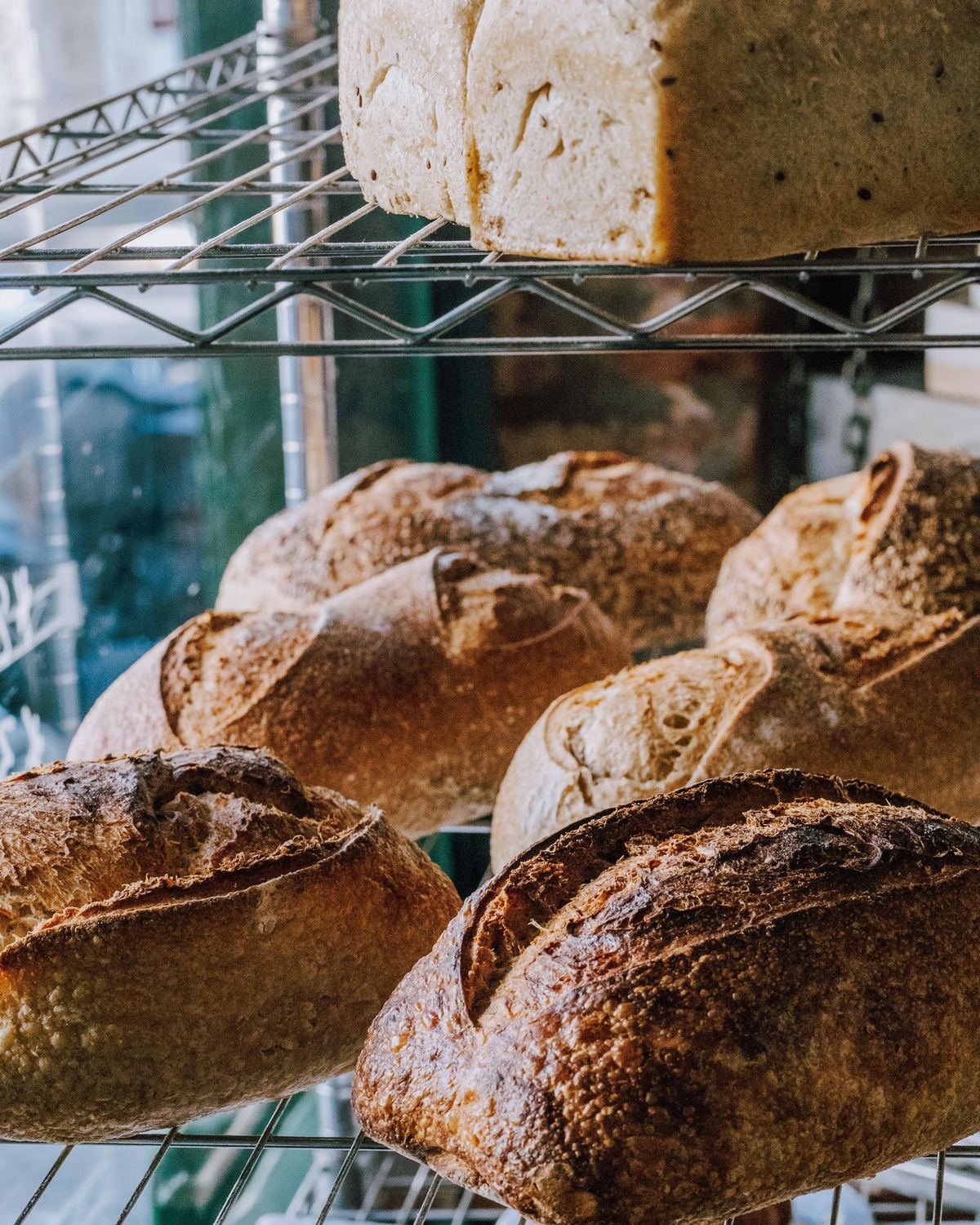 A busy Au Gourmand market stall stacked with loaves and pastries